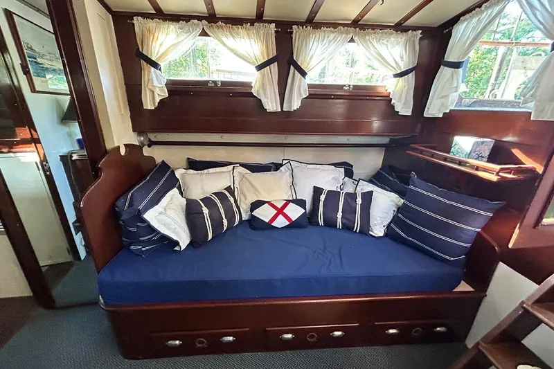 Slide: The Image of Cozy 1930 Classic 47' ACF yacht interior with nautical-themed cushions and wooden accents. - 13