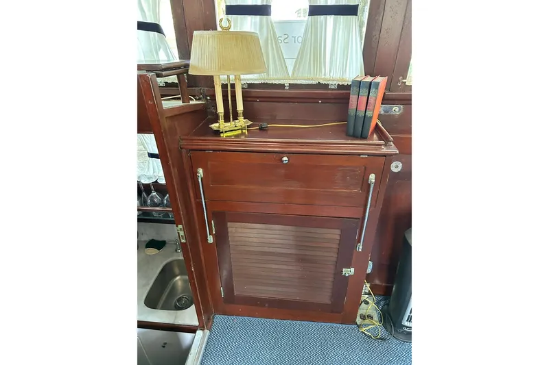 Slide: The Image of Vintage wooden cabinet with books and lamp on a 1930 Classic 47' ACF yacht. - 19