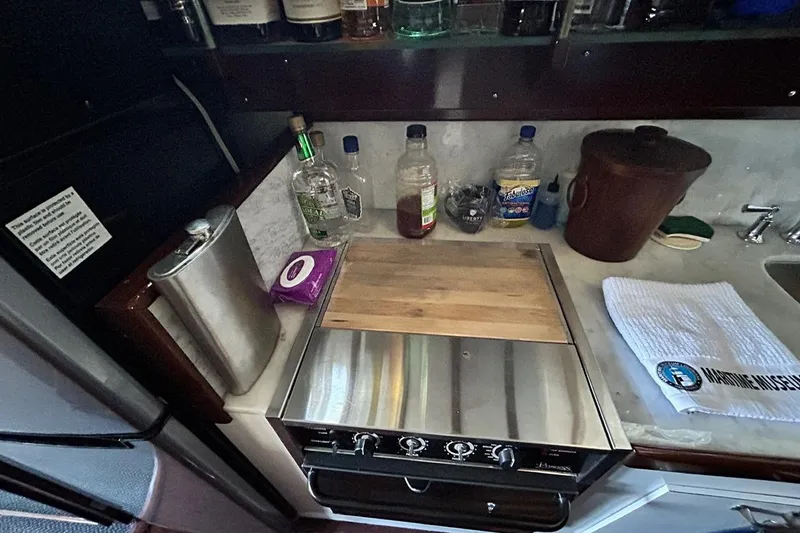 Slide: The Image of 1930 Classic 47' ACF yacht kitchen with stove, cutting board, and various bottles. - 21