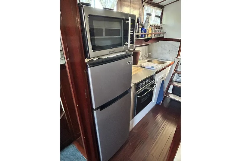 Slide: The Image of Compact kitchen in a 1930 Classic 47' ACF boat with modern appliances. - 26