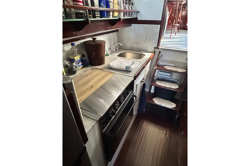 Slide: The Image of Compact kitchen in a 1930 Classic 47' ACF boat with wooden accents and modern appliances. - 27