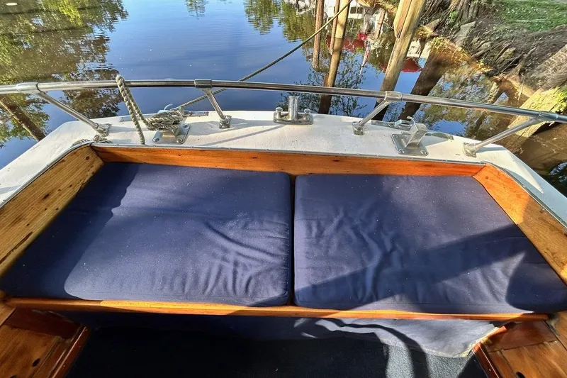 Slide: The Image of Classic 1930 47' ACF boat with cushioned seating, docked by a calm waterway. - 7