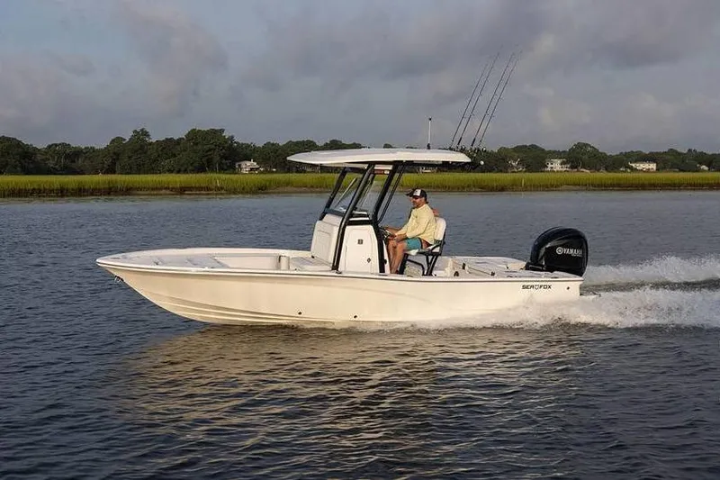 Slide: The Image of 2024 Sea Fox 251 Bay Fox boat cruising on a calm river with fishing rods. - 3