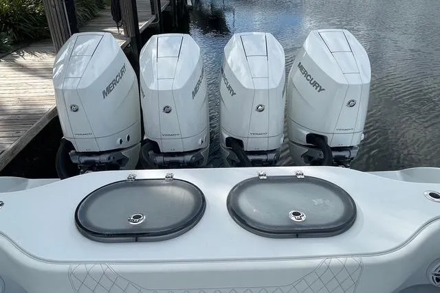 Slide: The Image of 2023 Conch 41 Center Console with four Mercury outboard engines docked by water. - 36