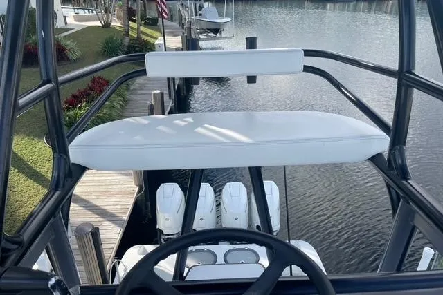 Slide: The Image of 2023 Conch 41 Center Console boat with helm view, docked by a serene waterfront. - 4