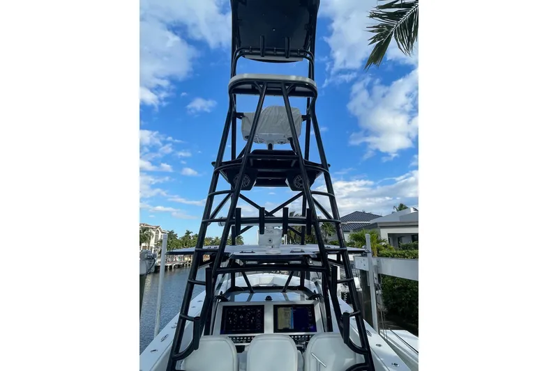 Slide: The Image of 2023 Conch 41 Center Console boat with tower, docked under a blue sky. - 6