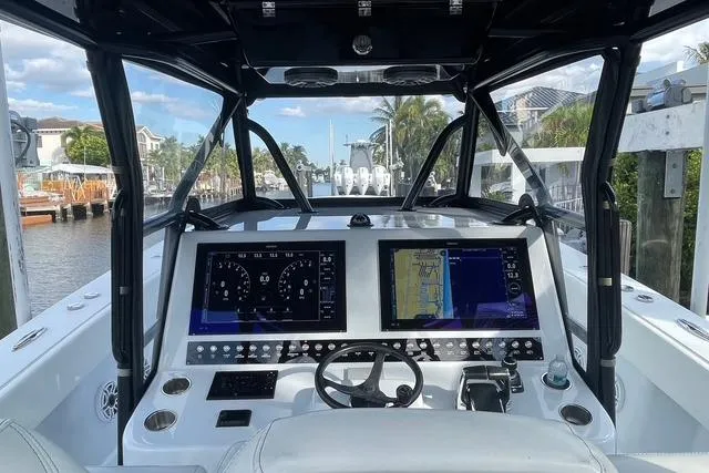Slide: The Image of 2023 Conch 41 Center Console boat dashboard with navigation screens and steering wheel. - 7