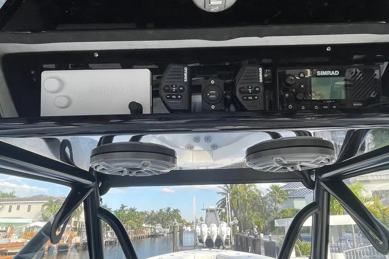 Slide: The Image of 2023 Conch 41 Center Console boat with Simrad electronics and speakers, docked near waterfront homes. - 9