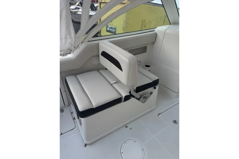 Slide: The Image of 2021 Sailfish 245DC boat interior with white cushioned seating. - 12