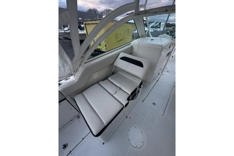 Slide: The Image of 2021 Sailfish 245DC boat interior with white cushioned seating and sleek design. - 16