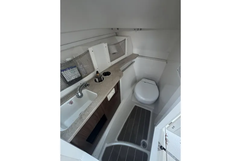 Slide: The Image of 2021 Sailfish 245DC boat interior with sink, toilet, and storage. - 18