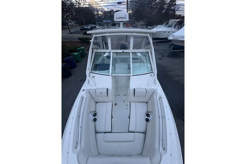Slide: The Image of 2021 Sailfish 245DC boat with white seating and Garmin equipment, docked outdoors. - 20