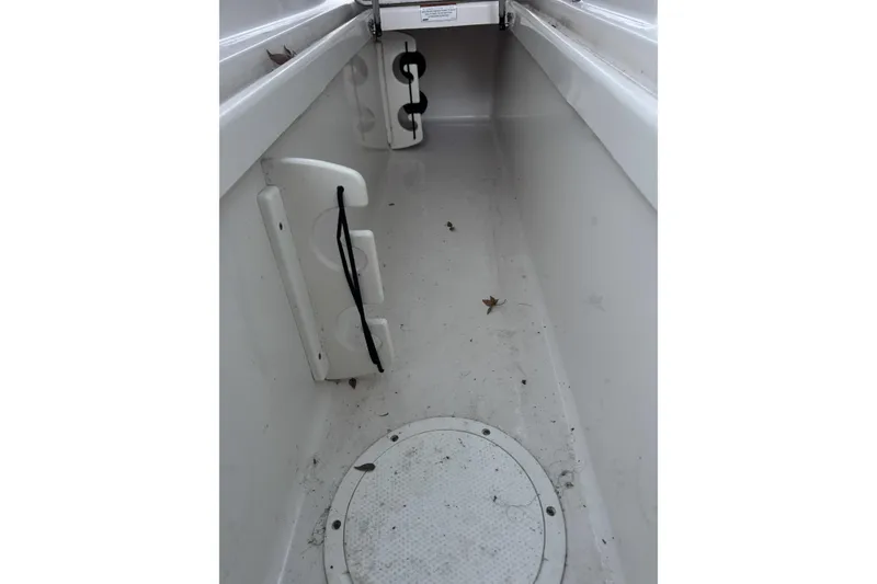 Slide: The Image of Interior view of 2021 Sailfish 245DC boat storage compartment with leaves and debris. - 23