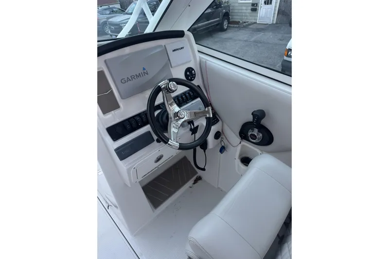 Slide: The Image of 2021 Sailfish 245DC boat helm with Garmin navigation and Mercury controls. - 24