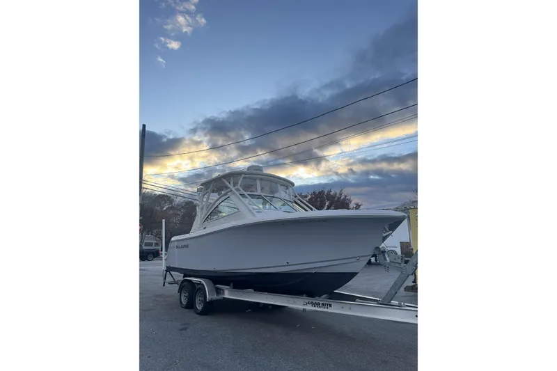 Slide: The Image of 2021 Sailfish 245DC boat on trailer at sunset, showcasing sleek design. - 3