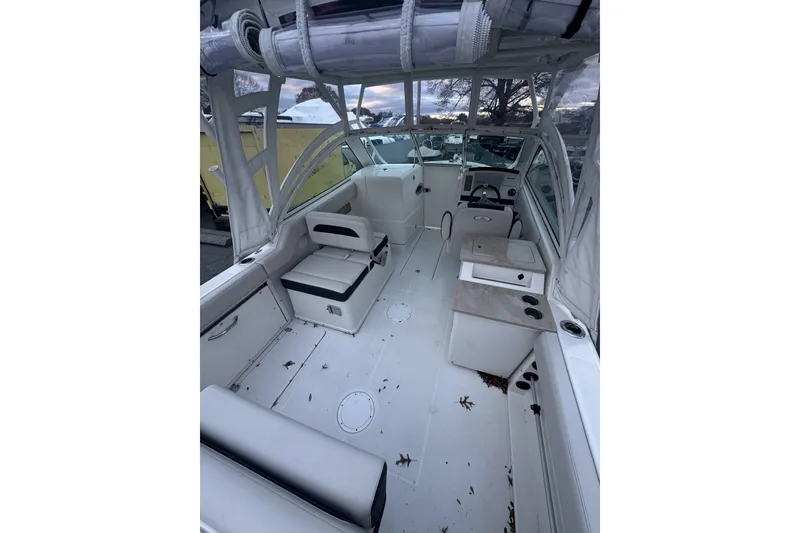 Slide: The Image of 2021 Sailfish 245DC boat interior with seating, steering wheel, and storage compartments. - 31