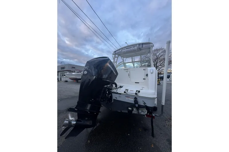 Slide: The Image of 2021 Sailfish 245DC boat with powerful outboard motor, parked outdoors under cloudy sky. - 32
