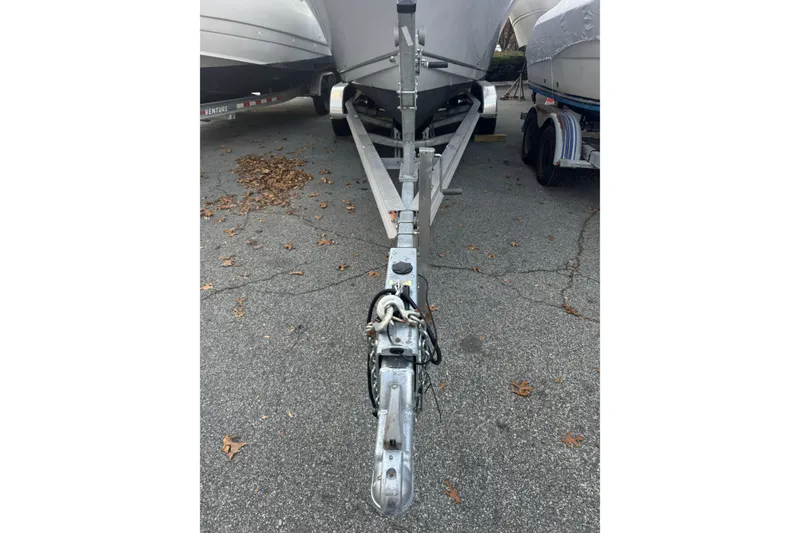 Slide: The Image of Trailer hitch of a 2021 Sailfish 245DC boat on pavement with fallen leaves. - 5