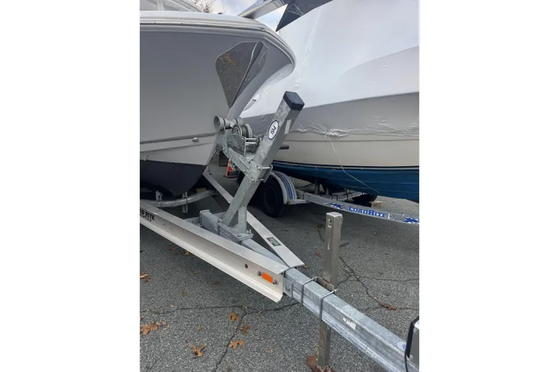 Slide: The Image of 2021 Sailfish 245DC boat on Load Rite trailer, parked on pavement. - 6