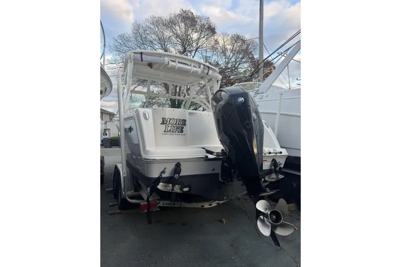 Slide: The Image of 2021 Sailfish 245DC boat with outboard motor, parked on a trailer. - 7