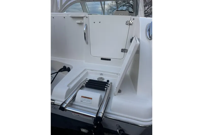 Slide: The Image of 2021 Sailfish 245DC boat with foldable swim ladder and storage compartment. - 8