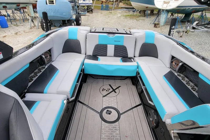 Slide: The Image of 2022 MasterCraft X24 boat interior with blue and gray seating, showcasing luxury and comfort. - 10