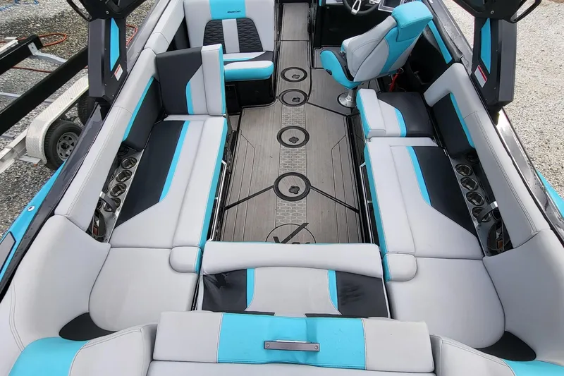 Slide: The Image of 2022 MasterCraft X24 boat interior with blue and gray seating, modern design. - 11