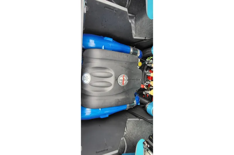 Slide: The Image of Engine compartment of 2022 MasterCraft X24 boat, featuring blue hoses and detailed components. - 13