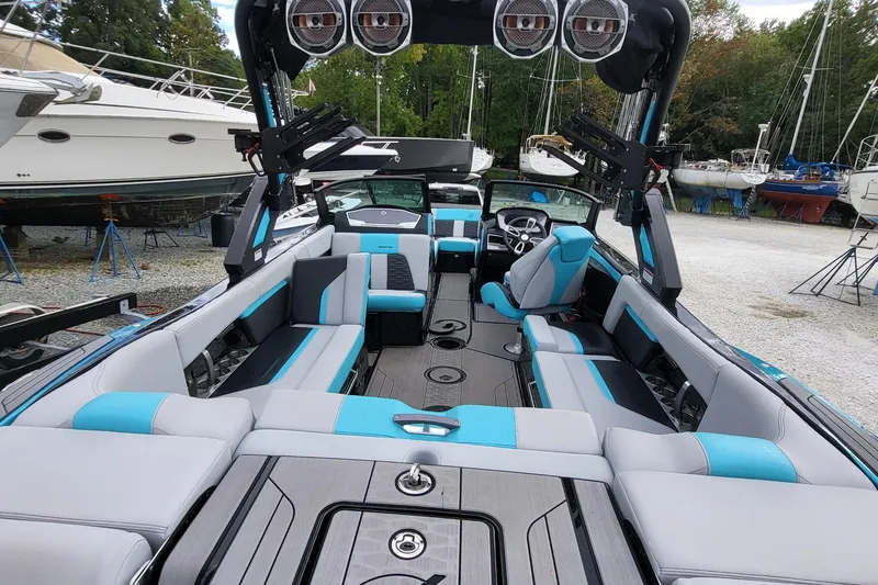Slide: The Image of 2022 MasterCraft X24 boat interior with blue and gray seating, advanced sound system, and sleek design. - 18