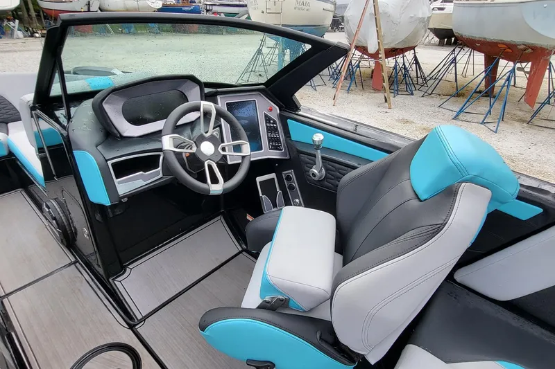 Slide: The Image of 2022 MasterCraft X24 boat interior with modern dashboard and blue-gray seating. - 8