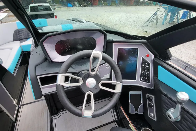 Slide: The Image of 2022 MasterCraft X24 boat dashboard with modern steering wheel and digital controls. - 9
