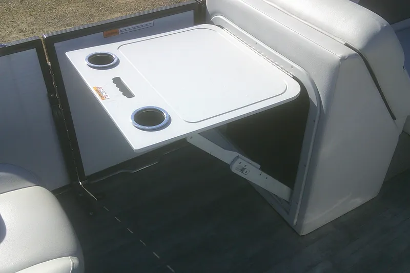 Slide: The Image of 2021 Crest Classic LX 220 SLC boat interior with foldable table and cup holders. - 12
