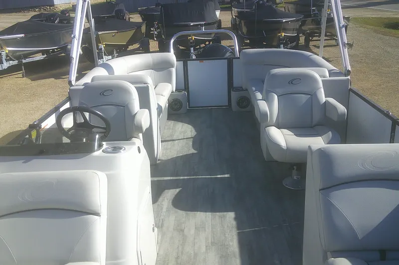 Slide: The Image of 2021 Crest Classic LX 220 SLC pontoon boat interior with plush seating and steering console. - 5