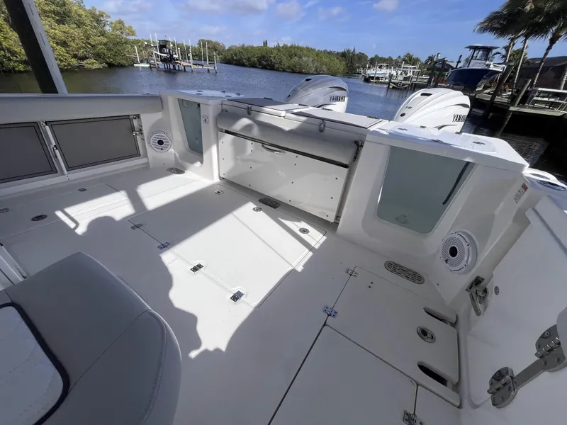 Slide: The Image of 2021 Sea Fox 368 Commander boat deck with Yamaha engines, docked by a scenic waterfront. - 20