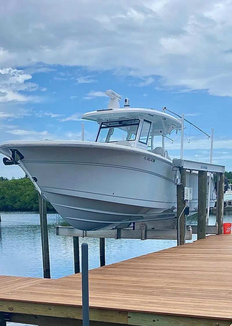 Slide: The Image of 2021 Sea Fox 368 Commander boat docked on a lift by a wooden pier. - 34