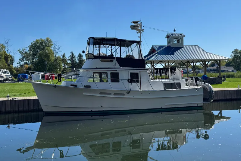The Image of 2001 Monk Trawler boat docked by a pavilion on a sunny day. - 0