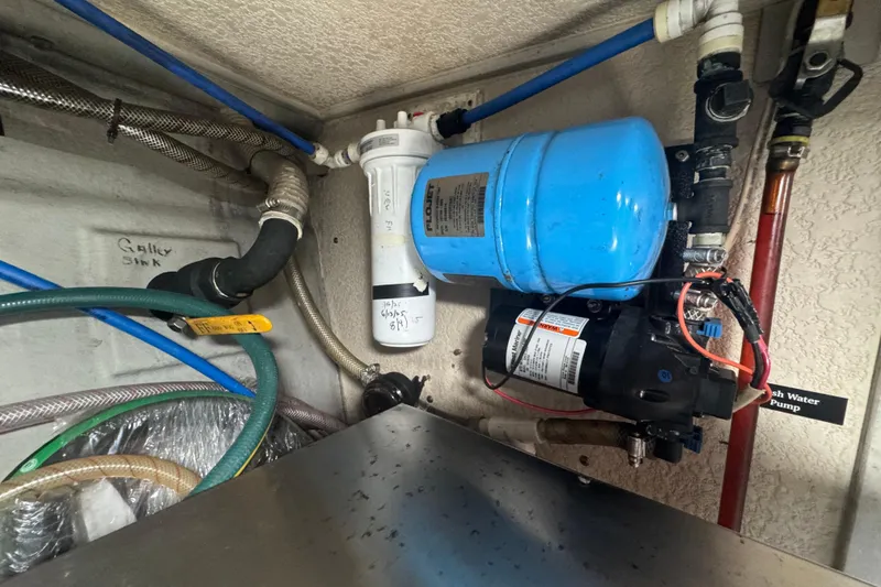 Slide: The Image of 2001 Monk Trawler water pump system with blue tank and labeled pipes. - 106