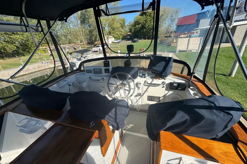 Slide: The Image of 2001 Monk Trawler helm with covered seats, steering wheel, and navigation equipment. - 11