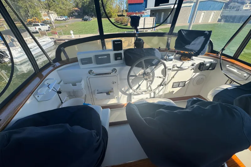 Slide: The Image of 2001 Monk Trawler helm with steering wheel, navigation equipment, and covered seats. - 12