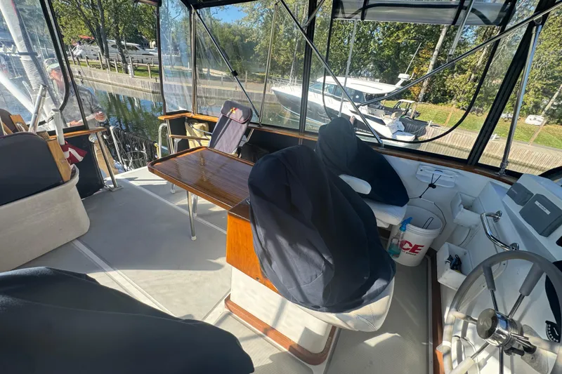 Slide: The Image of 2001 Monk Trawler interior with helm, seating, and table, docked near other boats. - 19