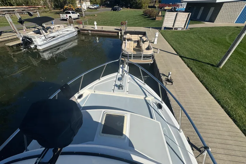 Slide: The Image of 2001 Monk Trawler docked at marina with nearby boats and green lawn. - 22