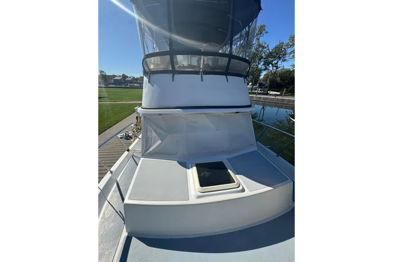 Slide: The Image of 2001 Monk Trawler boat deck with clear canopy and hatch, docked by green lawn. - 25