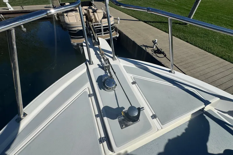 Slide: The Image of Bow of a 2001 Monk Trawler boat docked, featuring anchor chain and deck fittings. - 31