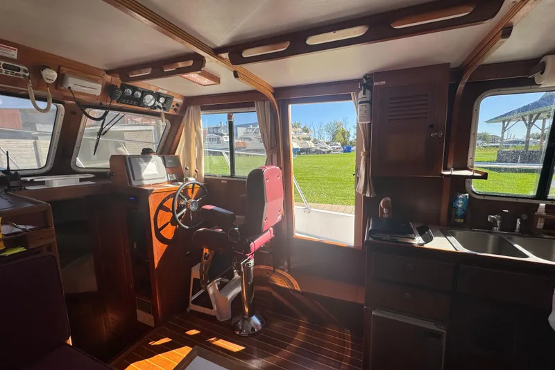 Slide: The Image of Interior of a 2001 Monk Trawler boat with steering wheel and kitchenette. - 34