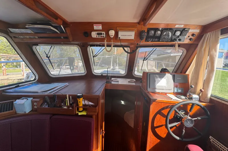 Slide: The Image of Interior of a 2001 Monk Trawler boat with navigation equipment and steering wheel. - 36