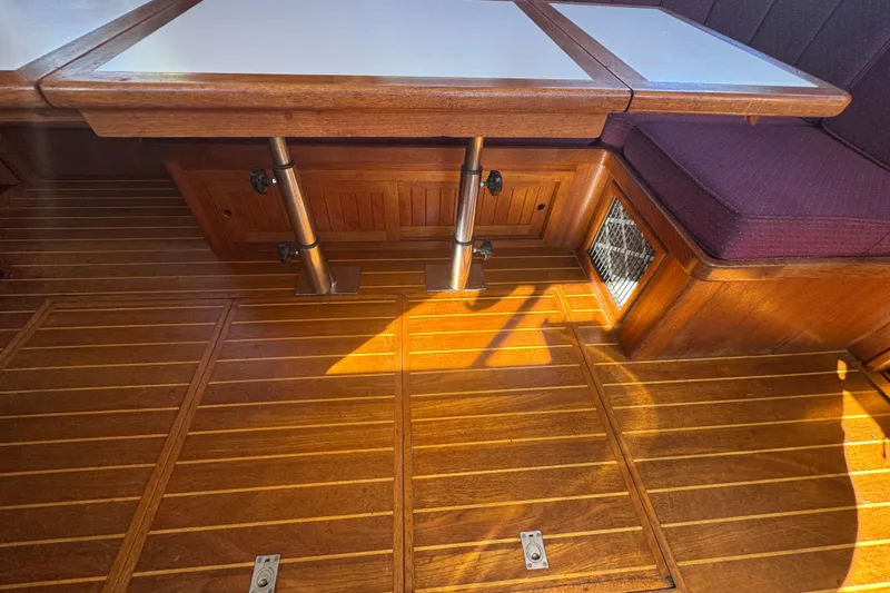 Slide: The Image of Wooden interior of a 2001 Monk Trawler, featuring a table and cushioned seating. - 46