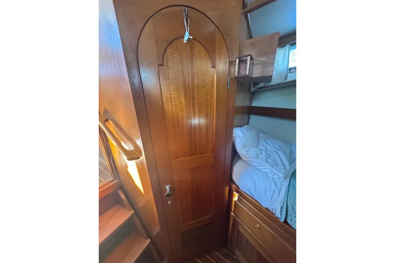 Slide: The Image of Wooden interior of 2001 Monk Trawler, featuring a door, stairs, and cozy sleeping area. - 67