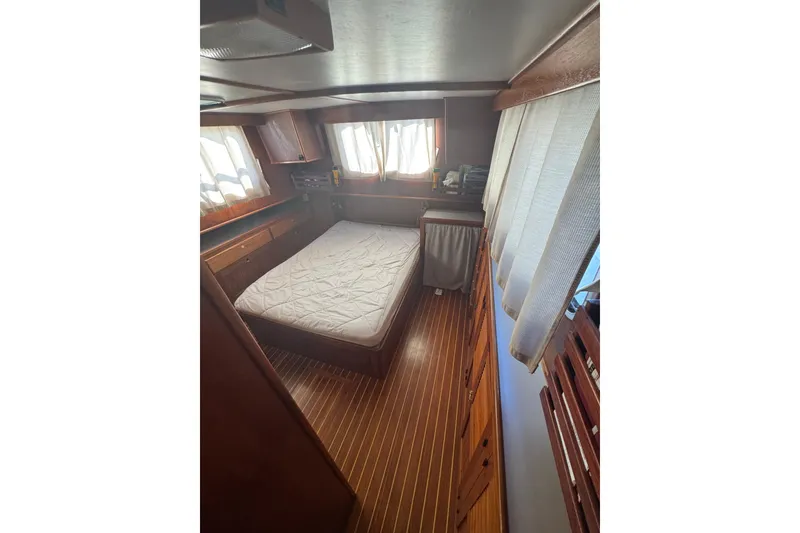 Slide: The Image of Cozy cabin interior of 2001 Monk Trawler with wooden furnishings and a comfortable bed. - 78