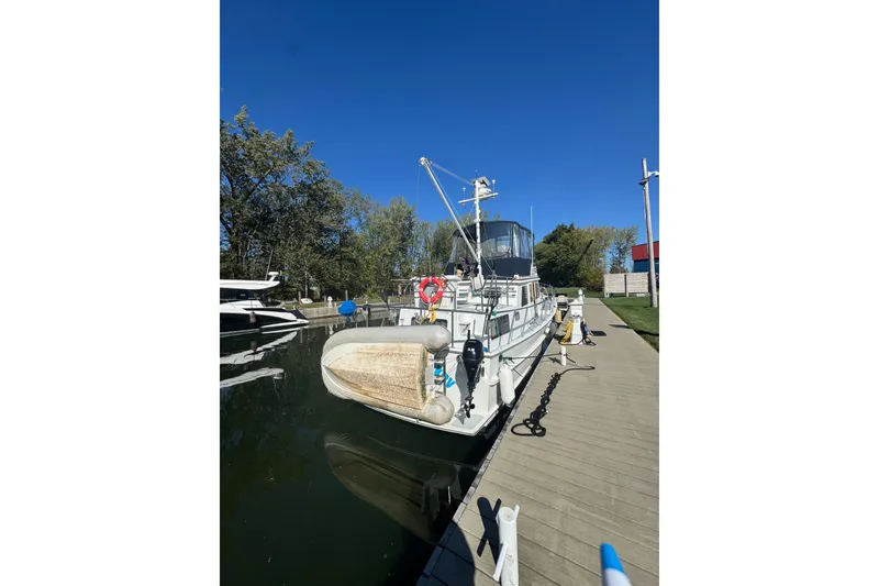 Slide: The Image of 2001 Monk Trawler docked at marina, clear blue sky, surrounded by trees. - 8