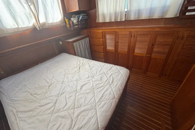 Slide: The Image of Cozy cabin interior of 2001 Monk Trawler with bed and wooden storage cabinets. - 84